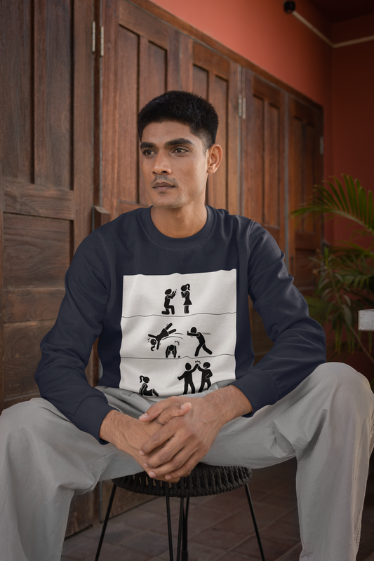 A person sitting on a chair wearing a black crewneck sweatshirt with text and graphic design on the front.