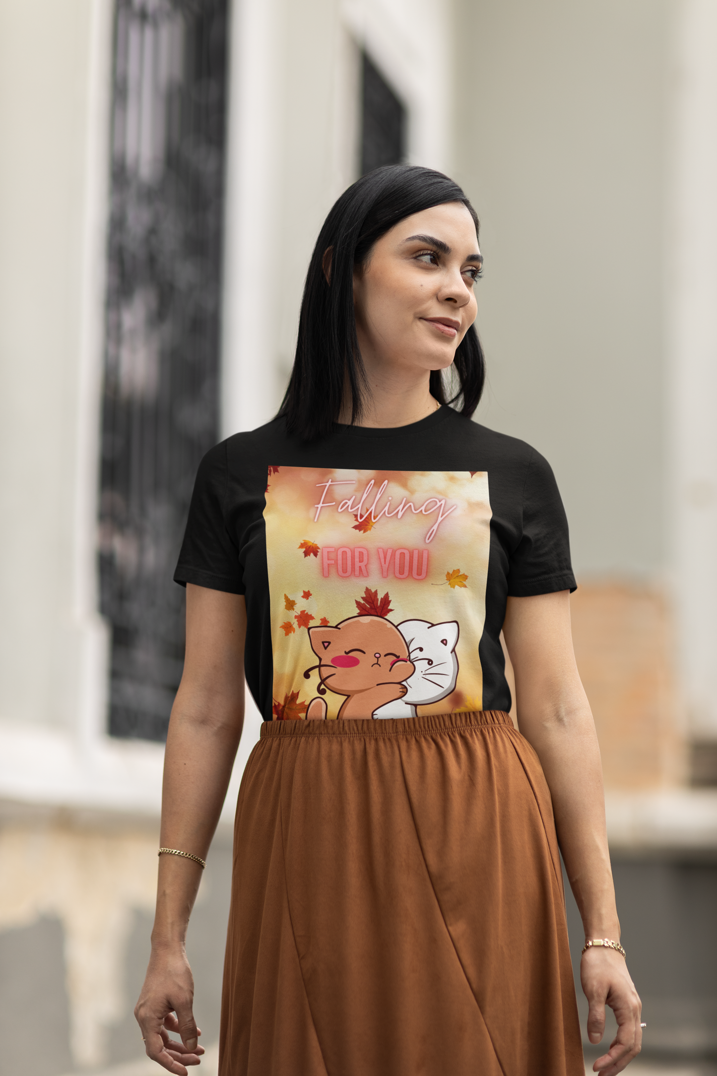 Woman wearing a black t-shirt with a colorful graphic design outdoors.