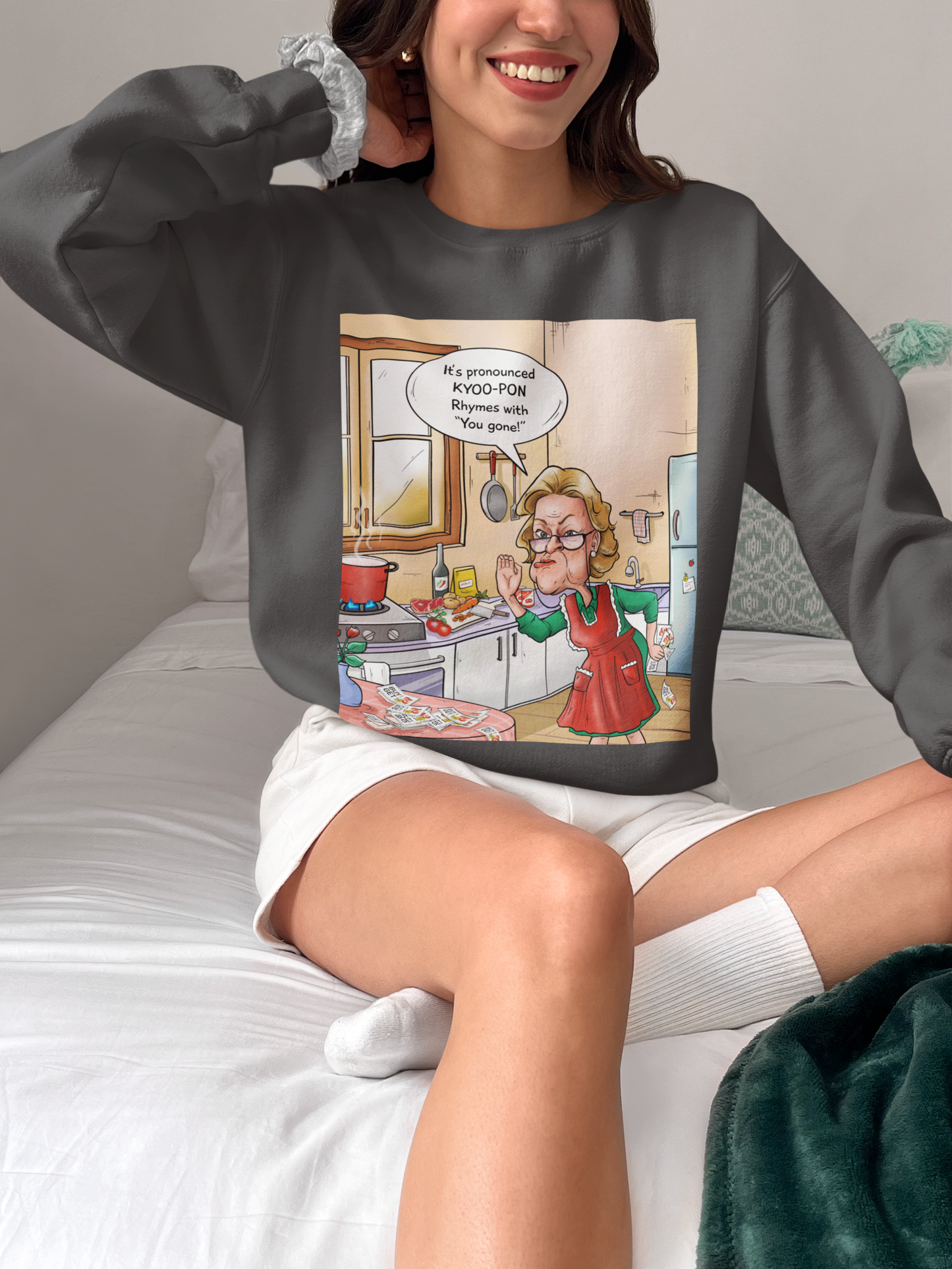 A person wearing a gray unisex heavy blend crewneck sweatshirt with a colorful cartoon print on the front.
