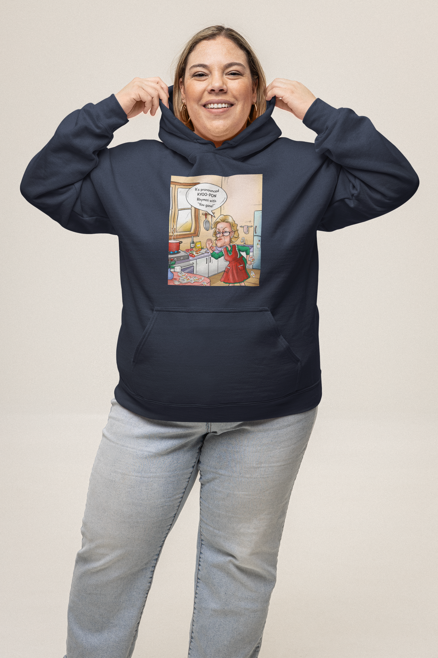 A person wearing a navy blue hooded sweatshirt with a graphic print in the center, standing against a beige background.