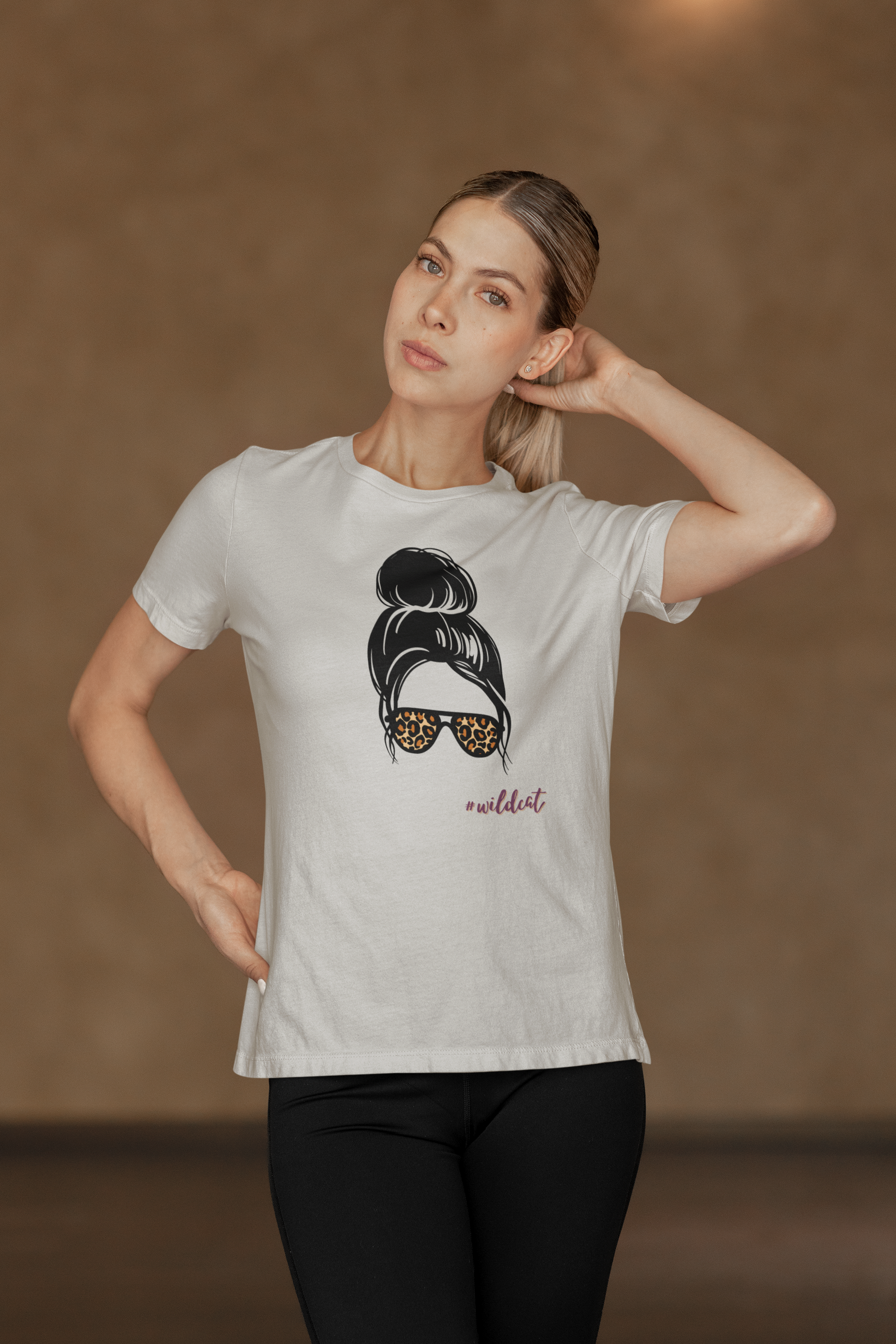 Woman wearing a white t-shirt with a graphic design on a brown background
